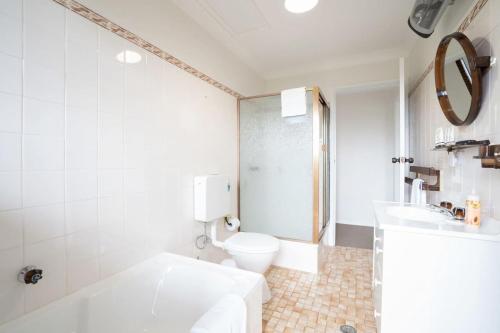 a white bathroom with a toilet and a sink at Mountain View Hideout with Stargazing Telescope in Wentworth Falls