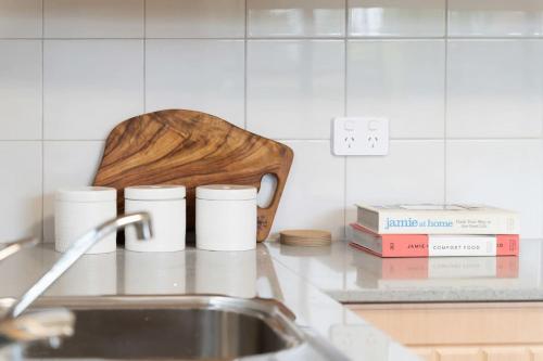 a kitchen counter with a sink and some books at Mountain View Hideout with Stargazing Telescope in Wentworth Falls