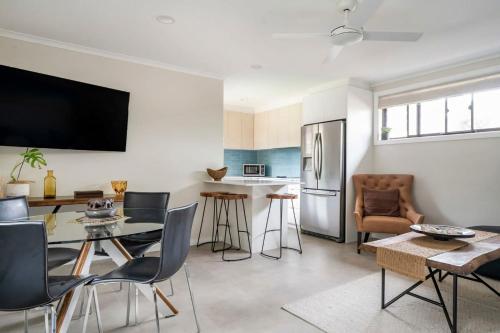 a kitchen and living room with a table and chairs at Oak Retreat Bliss by the Beach in Warriewood