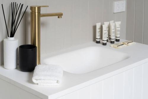 Eine Badezimmerablage mit Waschbecken und goldener Armatur in der Unterkunft Luxury Heritage Home 10min Walk to Scenic World in Katoomba