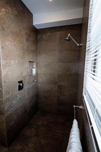 a bathroom with a shower with a glass door at The Emerald Bower in Rathmines
