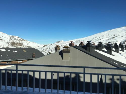 a snow covered roof of a building with mountains in the background at Hotel Casado in Pas de la Casa
