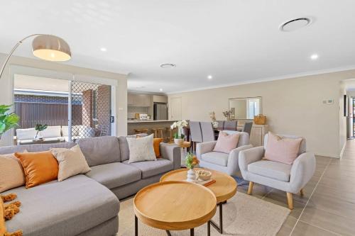 a living room with a couch and chairs and a table at Vineyard Oasis Heart of the Hunter in Cessnock