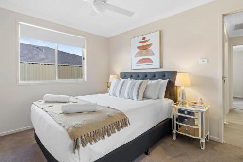 a bedroom with a large bed and a window at Vineyard Oasis Heart of the Hunter in Cessnock