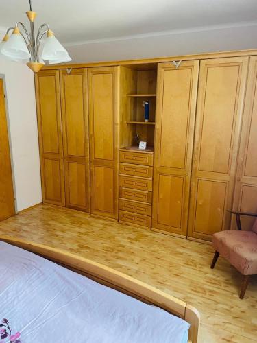 a bedroom with wooden cabinets and a bed and a chair at Haus LINDE Görtschitztal in Sankt Veit an der Glan
