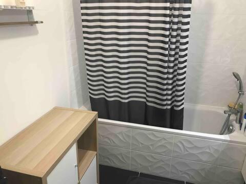 La salle de bains est pourvue d'un rideau de douche et d'une baignoire. dans l'établissement Manu s room Welcome, à Marseille