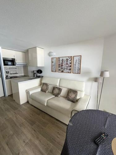 un salon avec un canapé blanc et une cuisine dans l'établissement Appartement pla d'adet aux pieds des pistes, à Cadeilhan-Trachère