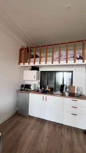 une cuisine avec des armoires blanches et un comptoir dans l'établissement Face à la mer, Trouville sur mer, à Trouville-sur-Mer