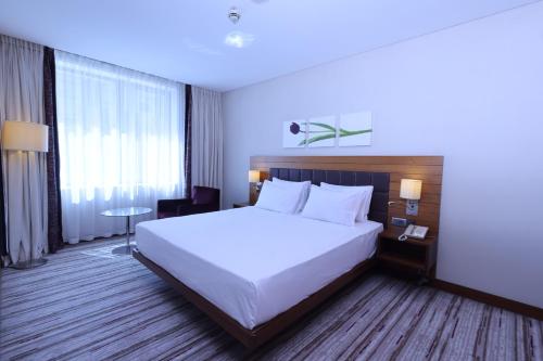 a bedroom with a large white bed and a large window at Hilton Garden Inn Konya in Konya