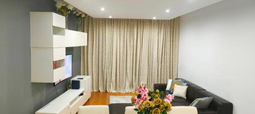 a living room with a couch and a tv at ADALBERTO NASCIMENTO LUXURY APARTA-HOSTEL At COLINAS DO CRUZEIRO in Odivelas