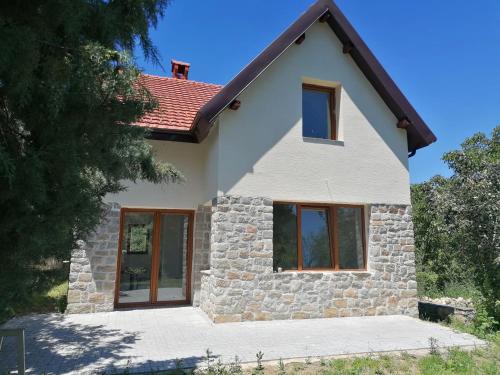 une maison blanche avec une façade en pierre dans l'établissement Pelister Villa, à Bitola