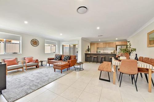 a living room with a dining room and a kitchen at Cessnock Haven Contemporary Country Retreat in Cessnock