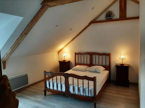 - une chambre avec un lit en bois et 2 lampes dans l'établissement Maison en pierre, à Saint-Pabu