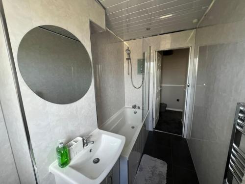 a bathroom with a sink and a mirror and a shower at Charming, Modern Flat sleeps 5 in Tayport