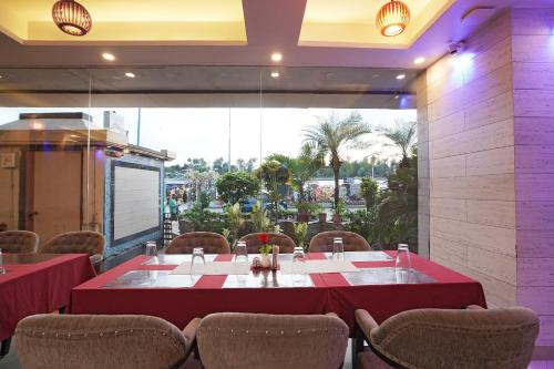 a dining room with a red table and chairs at Hotel JP - 100 meters from the beach in Digha