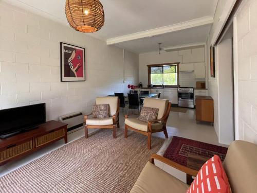 a living room with a couch and chairs and a tv at Broulee Pet Friendly Coastal Delight in Broulee