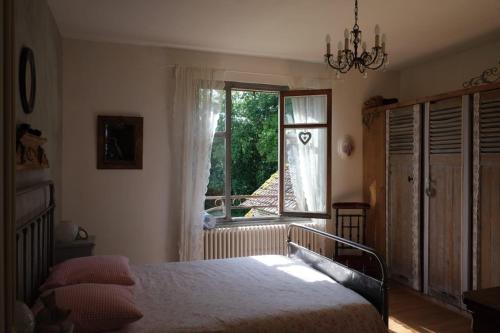 a bedroom with a bed and a window at L’hors-du temps in Le Tartre
