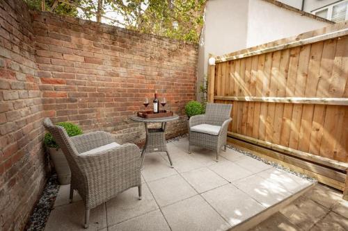a patio with chairs and a table and a fence at Central Medieval Grid Unique home with Gated parking in Bury Saint Edmunds