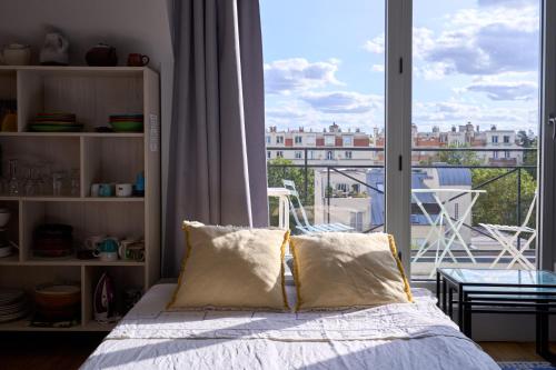 - une chambre avec un lit et un balcon dans l'établissement Studio Artiste Paris, à Paris