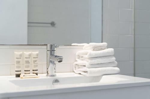 a pile of towels sitting on a bathroom sink at The Little Bondi Base in Sydney
