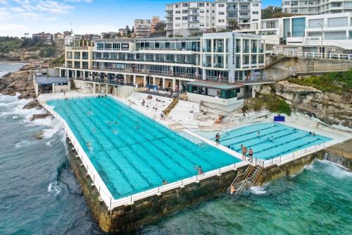 an overhead view of a swimming pool next to the ocean at The Little Bondi Base in Sydney