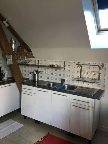 une cuisine avec des armoires blanches et un évier dans l'établissement Superbe T2 dans grange, calme absolu, Pau à 10min, à Buros