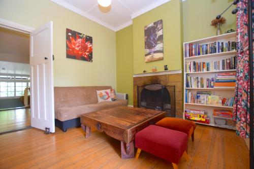 a living room with a couch and a table at Waragil Cottage - Original Settler's Home in Blackheath