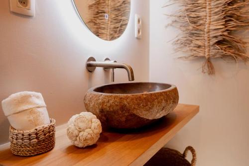 Un baño con un lavabo sobre una encimera de madera. en Luxe chalet met sauna in een oase van rust, en Hulshout