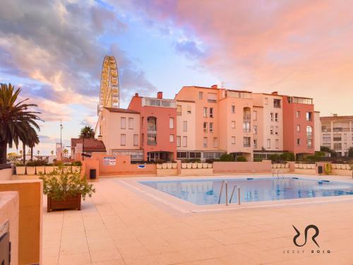 une grande piscine devant certains bâtiments dans l'établissement Studio Cap d’Agde à 50m du port avec piscine, au Cap d'Agde