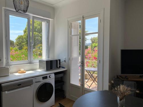 une cuisine avec une machine à laver et une fenêtre dans l'établissement R1D Les Pléiades de l'Estérel - Agay, à Agay