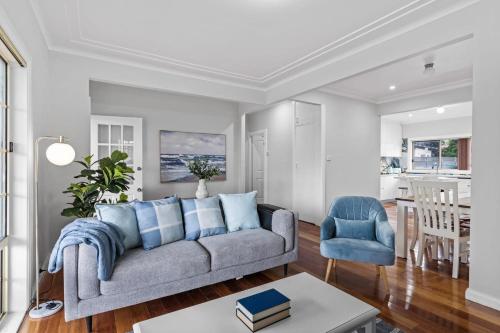 a living room with a couch and a table at Driftwood Cottage Your Coastal Haven in Lemon Tree Passage