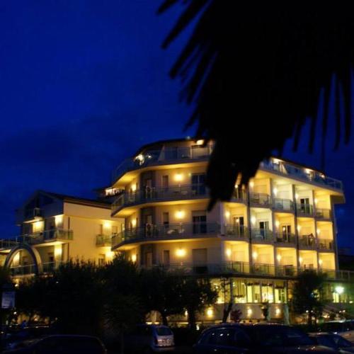 a large white building with lights on at night at Hotel Lady Mary in Milano Marittima