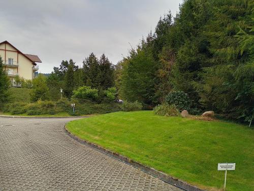a street with a sign in the grass next to a house at Apartament Alias in Wisła