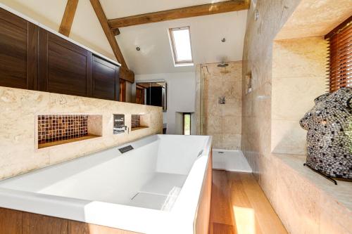 a bathroom with a large white tub and a fireplace at Hilltop View with Hot Tub in Brecon