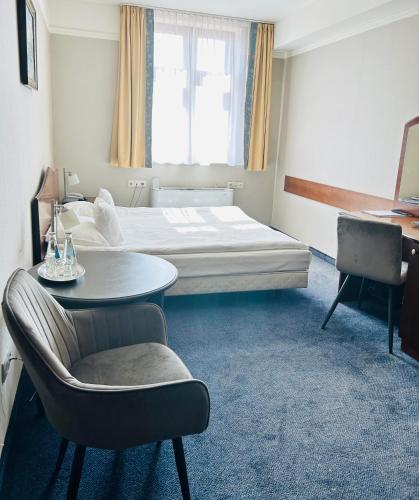 a hotel room with a bed and a table and a chair at Hotel Ambasadorski Rzeszów in Rzeszów
