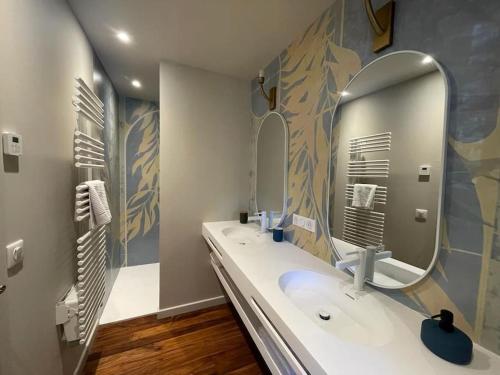 une salle de bain avec deux lavabos et un grand miroir dans l'établissement Domaine Farandole, à Eygalières