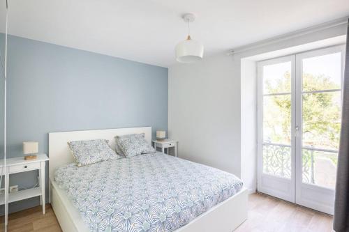 a white bedroom with a bed and a window at Le Grimont - 5 min de DisneyLand Paris in Coupvray