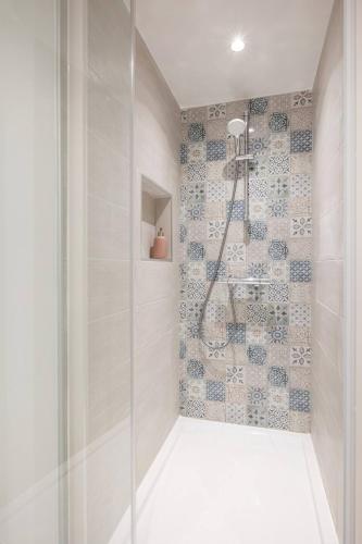 une douche avec une porte vitrée dans une salle de bain dans l'établissement Le Grimont - 5 min de DisneyLand Paris, à Coupvray