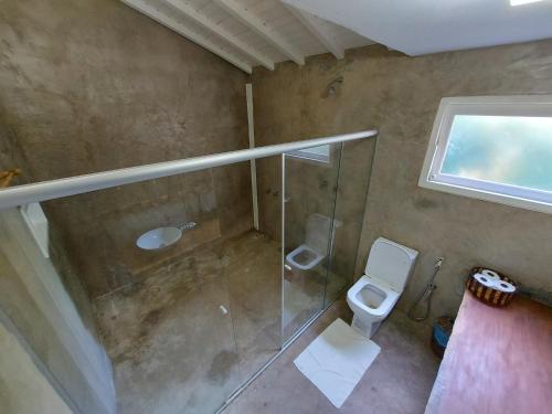 a bathroom with a shower and a toilet at Pousada Vila do Mar in Caraíva
