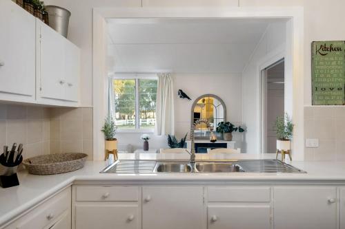 a kitchen with white cabinets and a sink at Janie s Cottage Secluded Wine Country Home in Broke