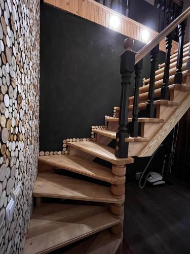 a staircase in a house with wooden stairs and a wall at Карпатський двір in Krivorovnya