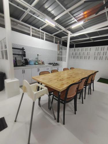 a dining room with a wooden table and chairs at RUMAH ADAM Homestay Bukit Changgang Private Pool in Kampong Kubang Beras