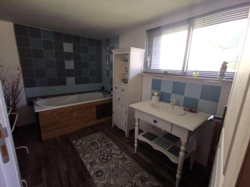 La salle de bains est pourvue d'une baignoire, d'un lavabo et d'une baignoire. dans l'établissement Le Vingt-Six, à Rochefort-sur-Loire