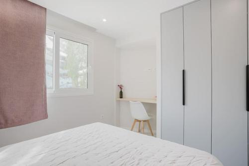 a white bedroom with a bed and a desk at Apartamento Brisa Marina in Arona