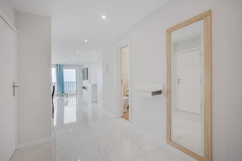 a white hallway with a mirror and a door at Apartamento Brisa Marina in Arona