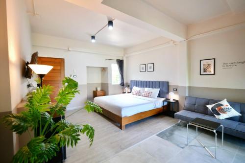 un dormitorio con una cama y un sofá en Alisse Stay Phuket Layan, en Phuket