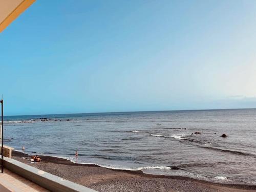 a beach with a group of people in the water at Apartamento Brisa Marina in Arona