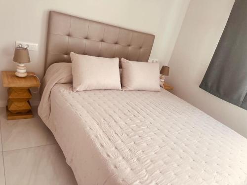 a bed with white sheets and pillows in a bedroom at Apartamento Brisa Marina in Arona