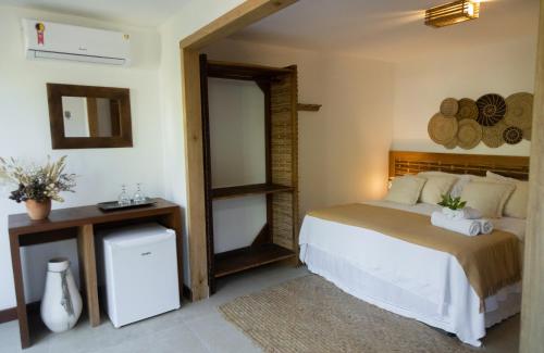 a bedroom with a bed and a mirror at Pousada Vila do Mar in Caraíva