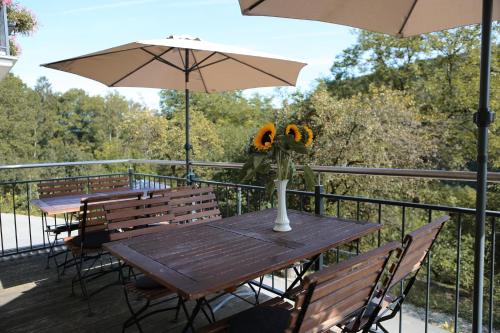 a table with a vase of flowers on a deck at Ferienwohnungen Porisch in Egloffstein